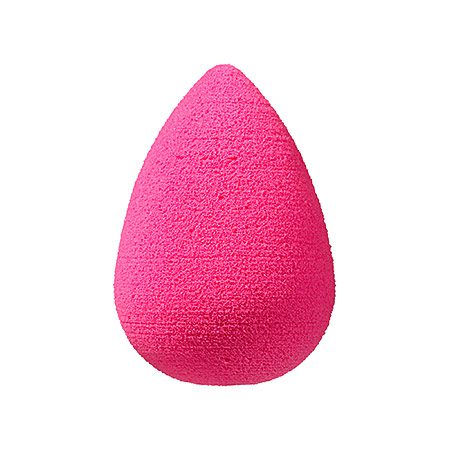 A pink beauty blender is sitting on the floor.