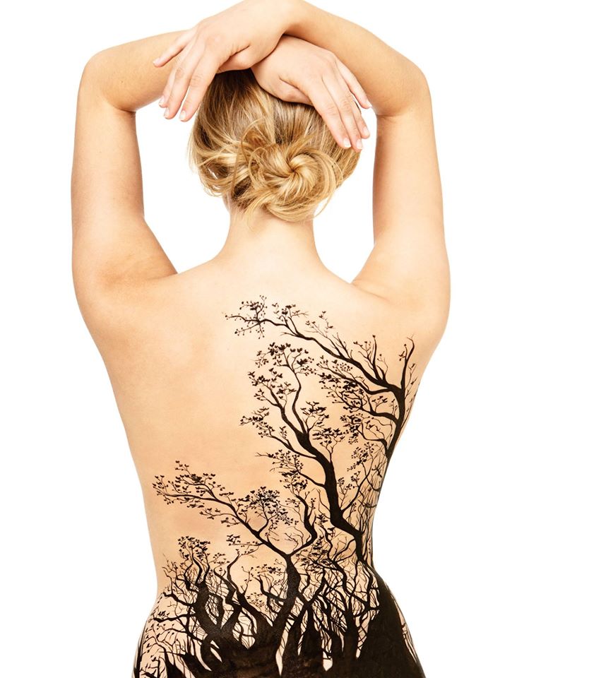 A woman with trees paint on her back
