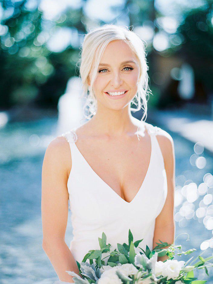 A woman with white hair wearing a simple wedding gown